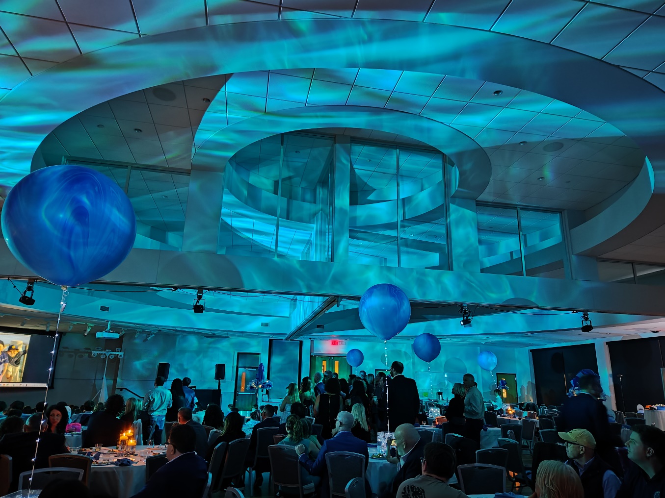 Rippling blue water-effect light projected across the ceiling of a banquet hall